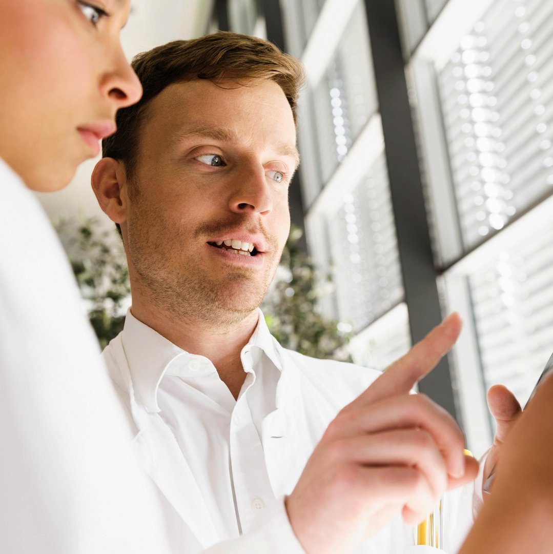 Scientist explaining software to co-worker Scientist explaining software to co-worker