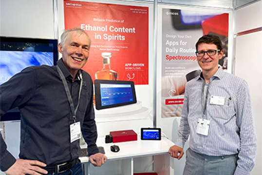 Two members of the labCognition team standing in front of a wall at a fair